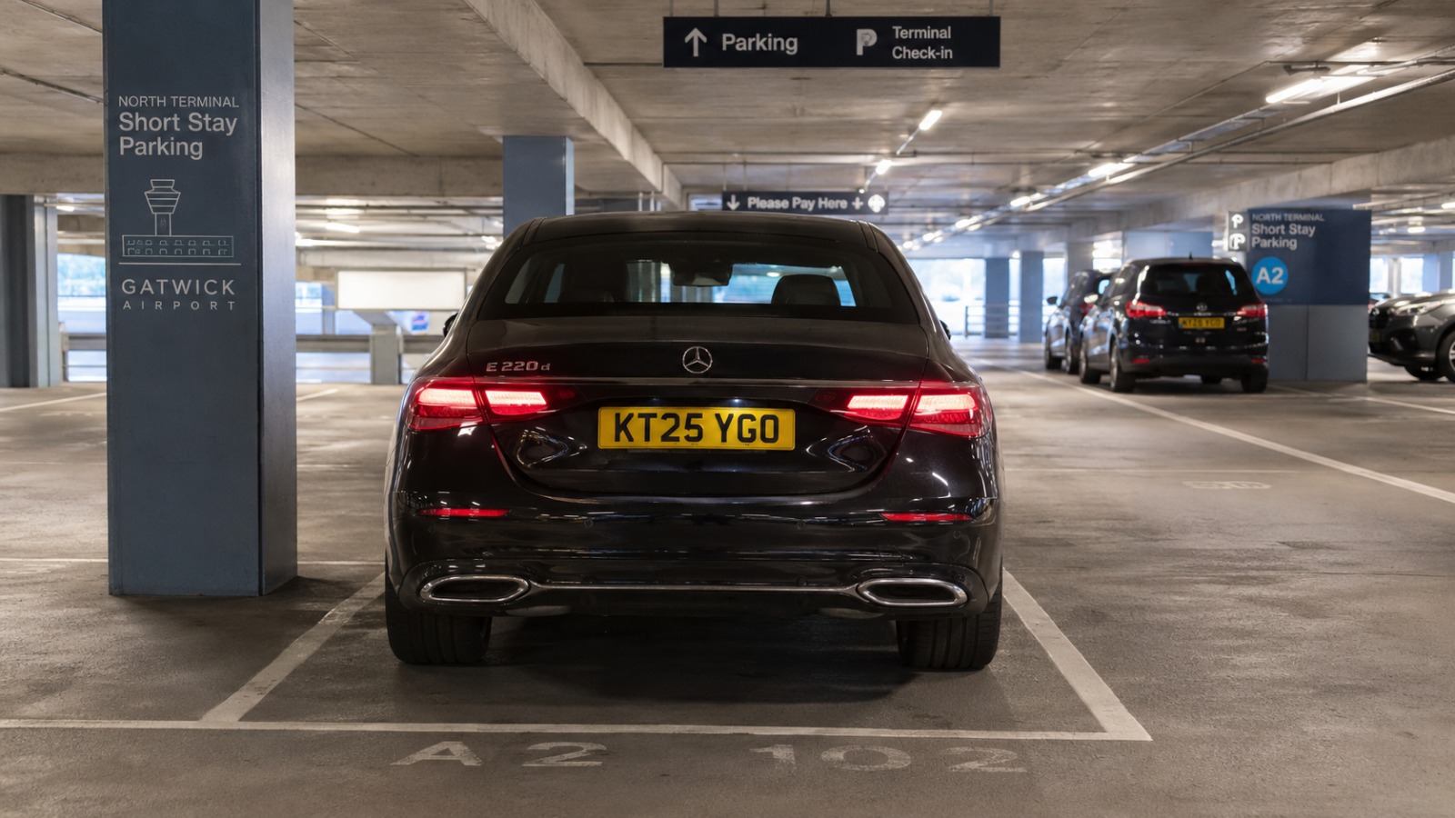 Saloon taxi waiting in a marked bay of a UK airport short stay car park for a Gatwick pickup